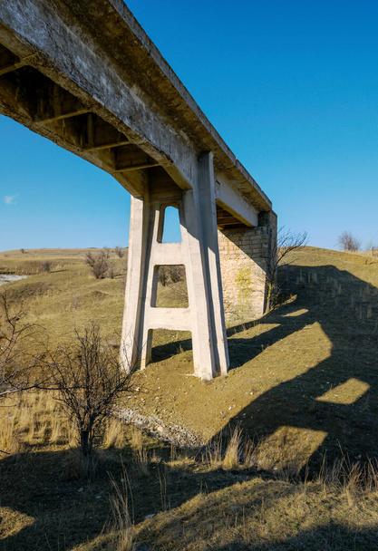 Antiga ponte ferroviária abandonada detalhe pilar de suporte de monólito de concreto na estepe
 - Foto, Imagem