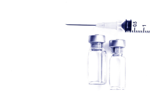 Frasco para injetáveis de medicamentos ou vacinas e seringa de plástico de 3 ml com agulha isolada no fundo branco, tom azul
 - Foto, Imagem