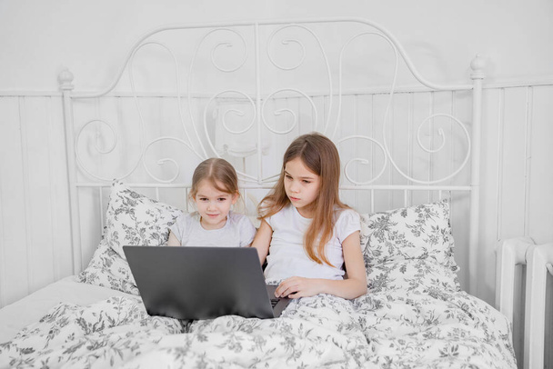 girls study on computer online at home bed. - Foto, Imagem