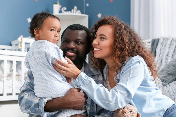 Szczęśliwi Afroamerykanie rodzice z uroczym dzieckiem w domu - Zdjęcie, obraz