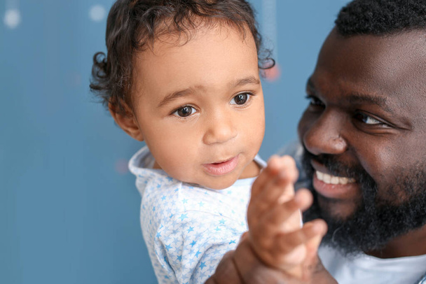 Feliz hombre afroamericano con lindo bebé en casa
 - Foto, imagen
