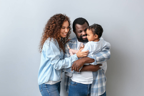 Ευτυχισμένοι Αφροαμερικανοί γονείς με χαριτωμένο μωρό σε λευκό φόντο - Φωτογραφία, εικόνα