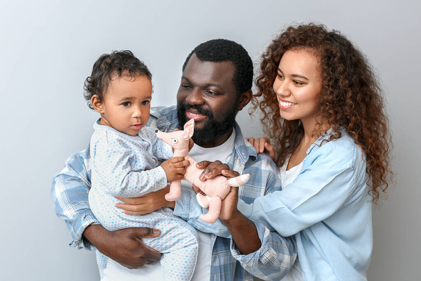 Ευτυχισμένοι Αφροαμερικανοί γονείς με χαριτωμένο μωρό σε λευκό φόντο - Φωτογραφία, εικόνα