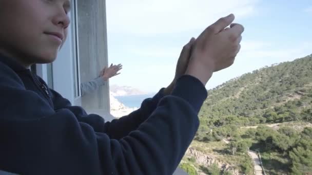 A család tapsol az orvosoknak az erkélyükről. Spanyolországban az emberek tapsolnak az erkélyeken és ablakokon az egészségügyi dolgozók támogatására a Coronavirus-járvány idején - Felvétel, videó