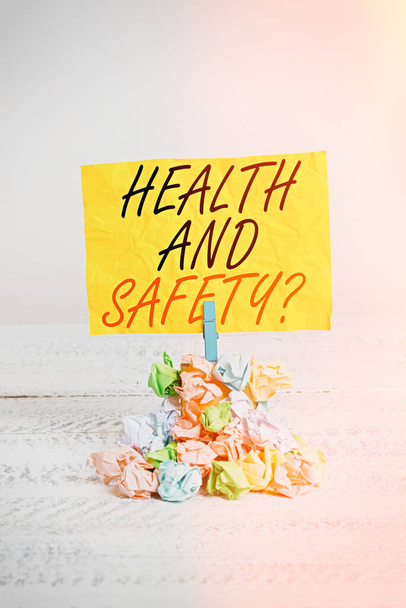 Word writing text Health And Safety. Business concept for procedures intended to prevent accident in workplace Reminder pile colored crumpled paper clothespin reminder white wooden space. - Photo, Image