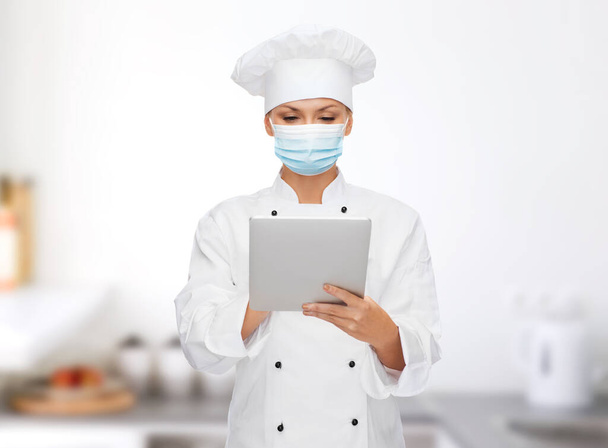 female chef in face mask with tablet pc computer - Valokuva, kuva