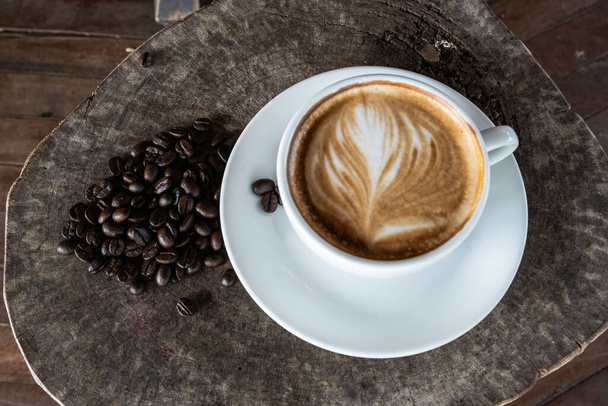 zár fekete kávébab egy fa háttér fehér kávé csésze. felülnézet - Fotó, kép