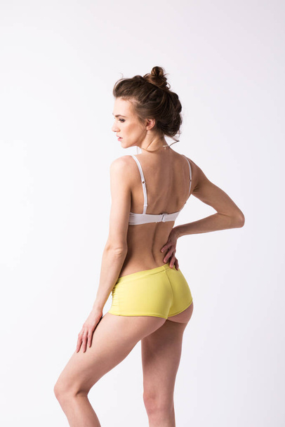 Fit, healthy and sporty woman in underwear on white. Sport, fitness, diet, weight loss and healthcare concept. - 写真・画像