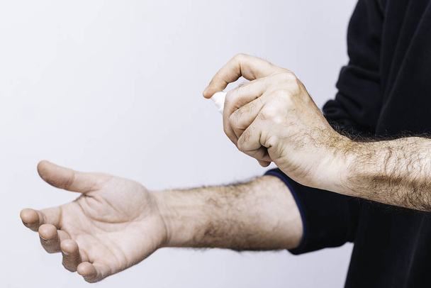 Homem limpando as mãos com álcool desinfetante Higiene conceitual, proteção contra Covid-19
 - Foto, Imagem