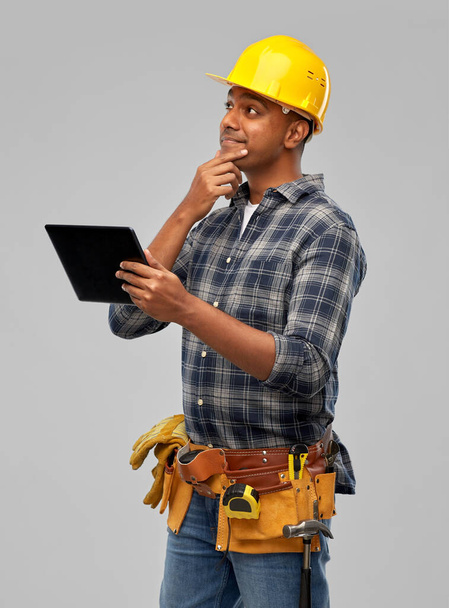 thinking indian builder in helmet with tablet pc - Foto, afbeelding
