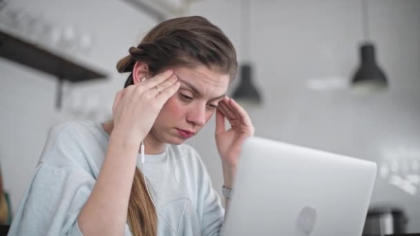 The young beautiful girl is working on a laptop. Strong headache. Massage of the temporal lobe. Upset student. Deep feelings of grief. - Footage, Video