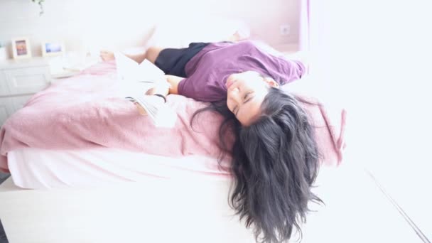 Young woman lying on bed during quarantine - Felvétel, videó