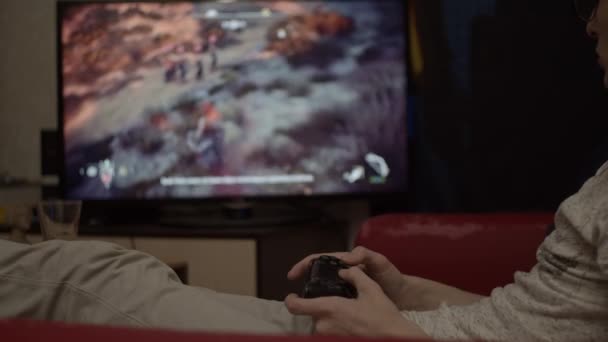 Νεαρός gaming στο σπίτι χρησιμοποιώντας pad παιχνίδι, ρηχό βάθος πεδίου - Πλάνα, βίντεο