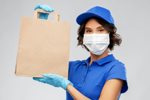 delivery woman in face mask with food in paper bag - Foto, Imagem