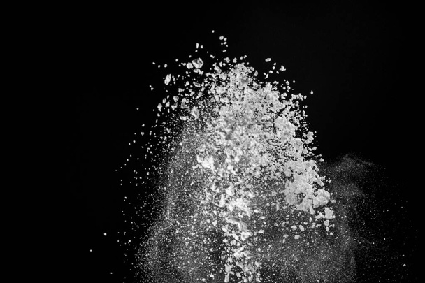 Uitbarsting van wit poeder met bloem en suiker creëren een prachtig patroon geïsoleerd op zwarte achtergrond 2020 - Foto, afbeelding