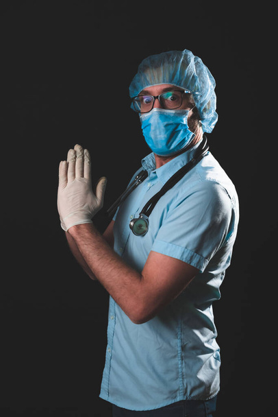 Arzt, Krankenschwester, Chirurg, Psychologe, der mit Schutzmaske, Brille und Handschuhen arbeitet und Menschen in Tagen der Panik hilft, Pandemie - Studioaufnahme auf schwarzem Hintergrund. - Foto, Bild