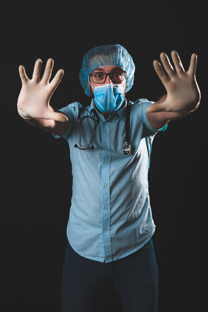 Medical doctor, nurse, surgeon, psychologist working with protective mask, glasses and gloves helping people in the days of panic, pandemic - studio shot on black background. - Valokuva, kuva