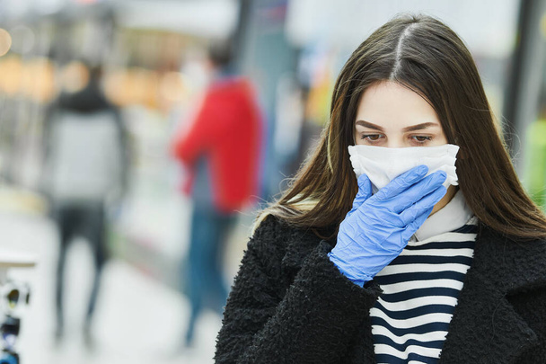 woman with face mask coughing at public place. coronavirus outbreak - 写真・画像