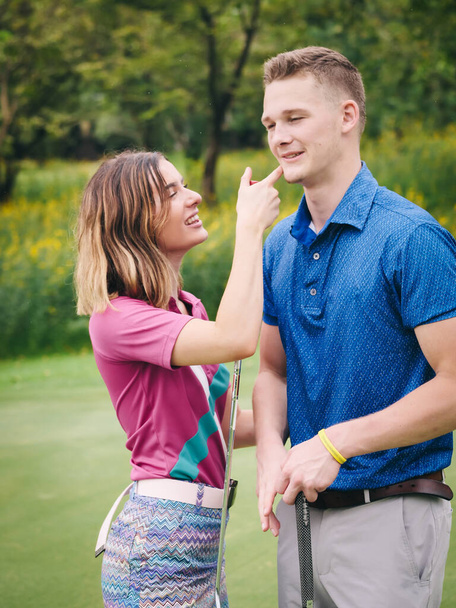 Happy golfer couple hugging and talking together at green field outdoor. - Foto, afbeelding