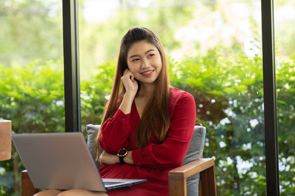 Business Asian young woman wearing red dress working with computer laptop and thinking to get ideas and requirement in Business startup feeling so happiness,Small Business Startup Concept - Foto, Imagen