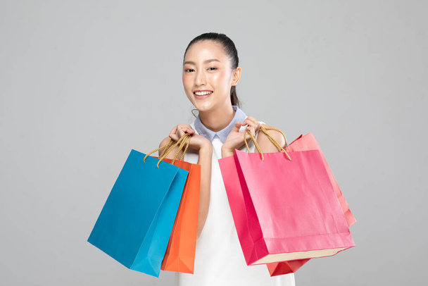Beautiful Attractive Asian Woman smile and holding shopping bags feeling so happiness and enjoy with black Friday sale in Shopping mall,isolated on white background,Shopping Concept - Fotoğraf, Görsel