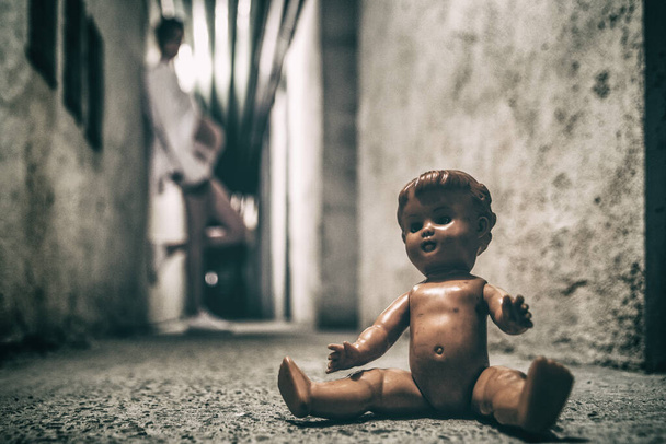 Έγκυος κορίτσι ποζάρουν σε σκοτεινό τούνελ με παλιά τρομακτική κούκλα - Φωτογραφία, εικόνα