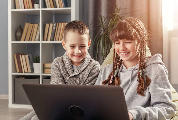 Two happy children using laptop - Foto, imagen