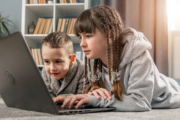 Two siblings using laptop - Φωτογραφία, εικόνα