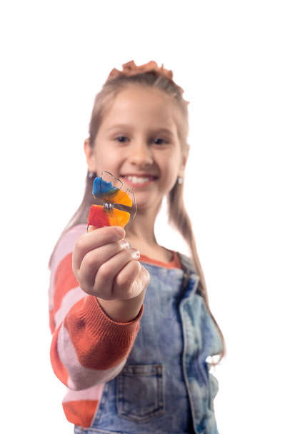 Ritratto di bambina con apparecchio ortodontico isolato su sfondo bianco. - Foto, immagini