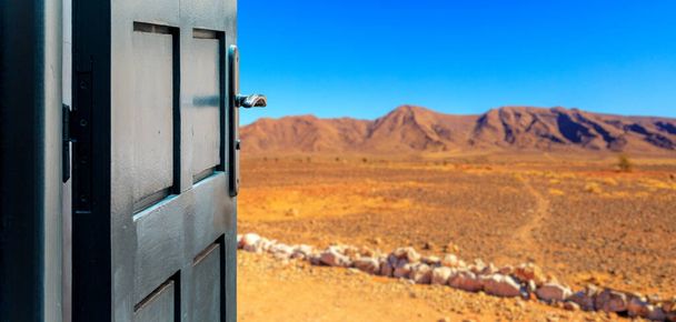 Opened door concept with a arid desert landscape in the background - Foto, afbeelding