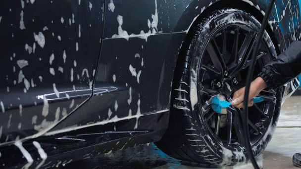 TOMSK, RUSSIA - March 30, 2020: Chevrolet Camaro ZL1 the Exorcist man brushes rear wheel disc - Foto, Bild