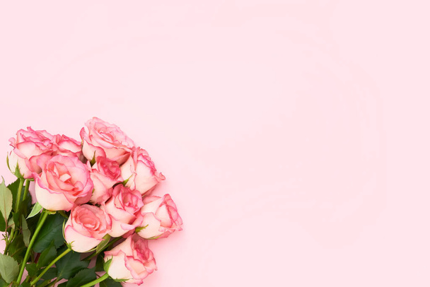 Bouquet of pink roses on pink background. Mothers day, Valentines Day, Birthday celebration concept. Greeting card. Copy space for text, top view - 写真・画像