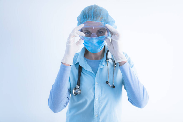 Врач, медсестра, хирург, психолог, работающий с защитной маской, очками и перчатками, помогающий людям в дни паники, пандемии
. - Фото, изображение