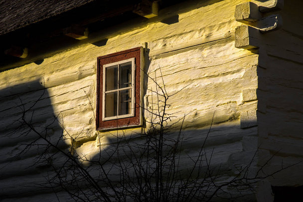 Oude venster op het gele huisje in dorp Vlkolinec, Slowakije - Foto, afbeelding