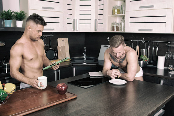Young attractive gay couple in the kitchen. - 写真・画像