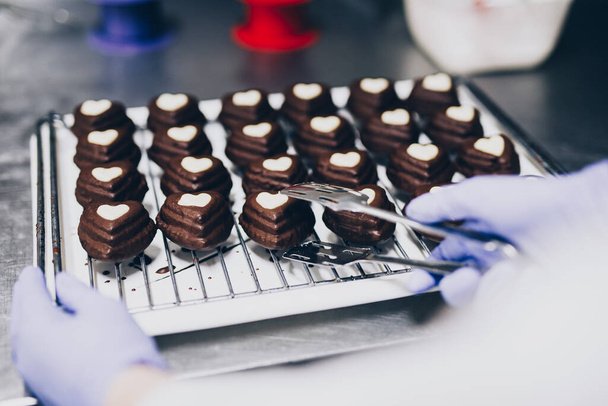 Шеф-повар делает печенье на рабочем столе пекарни
  - Фото, изображение