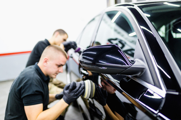 Detallado de coches, trabajadores con pulidores orbitales en taller de reparación de automóviles
.   - Foto, Imagen