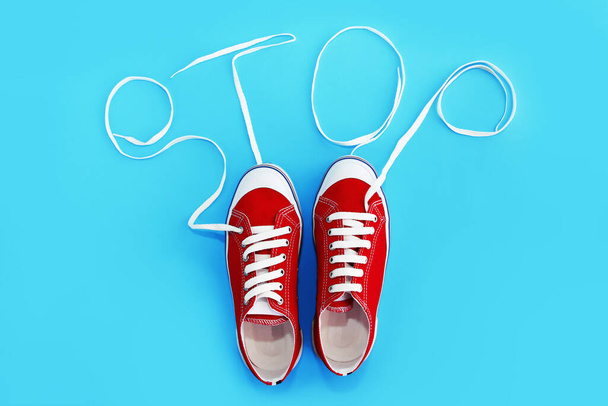 κόκκινα παπούτσια γυμναστικής με λευκά κορδόνια και η λέξη stop - Φωτογραφία, εικόνα