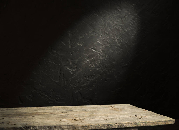 Old wood table with blurred concrete block wall in dark room background. - Fotografie, Obrázek