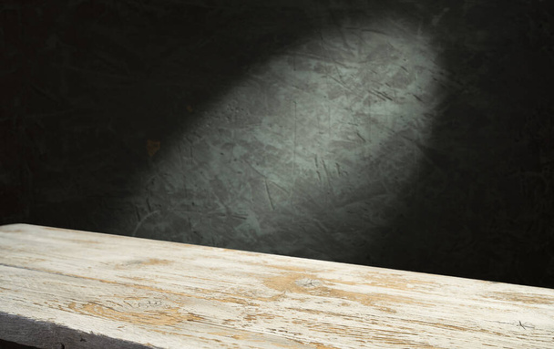 暗い部屋の背景にぼやけたコンクリートブロック壁と古い木のテーブル. - 写真・画像