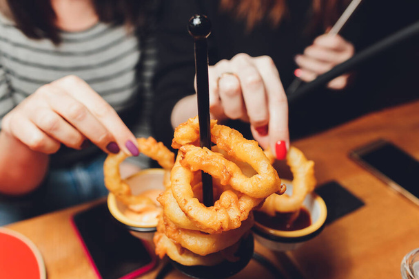onion rings with ketchup on a dark table. - Фото, изображение