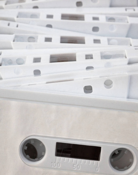 White cassette tapes (compact cassettes or musicassettes, MC). Analog magnetic tape recording format for audio recording and playback. - Photo, image