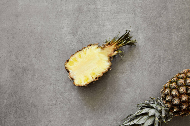 Ízletes érett gyümölcsök trópusi ananász szürke kő háttér. - Fotó, kép