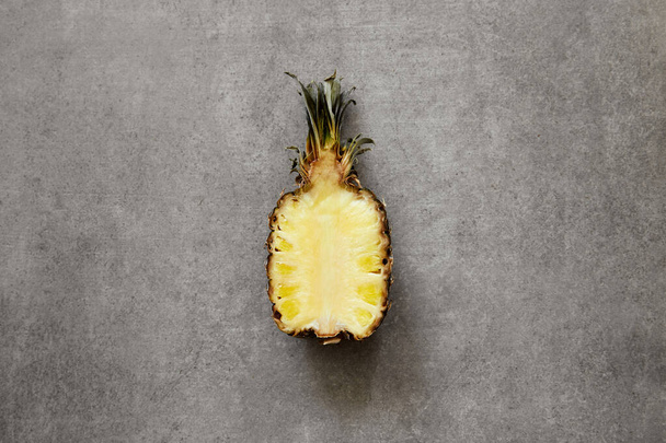 Half of tropical pineapple on a gray concrete surface. - Foto, immagini