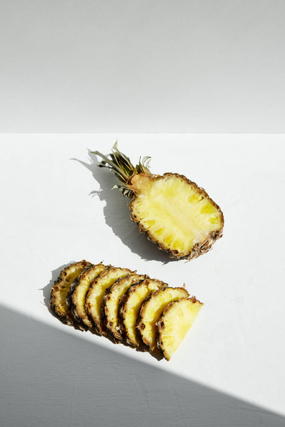 Ananas tranchés juteux mûrs et géométrie de l'ombre sur un fond clair
. - Photo, image