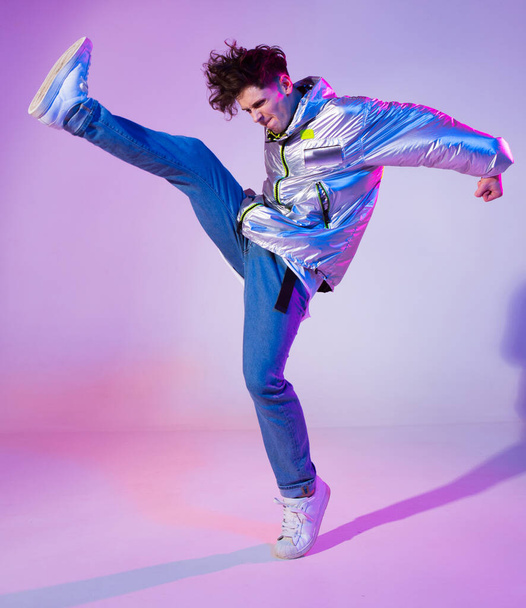 Cool guy dancing contemporary dance in studio. Neon light background. Acrobatic bboy dancer. Break dance lessons. - Foto, imagen