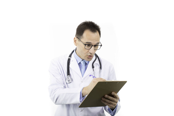 Έκπληκτος γιατρός συμπληρώνοντας ιατρική φόρμα στο πρόχειρο, λευκό φόντο - Φωτογραφία, εικόνα