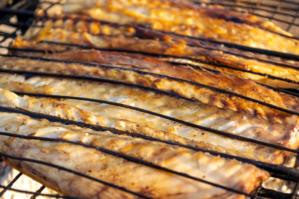 Baked mackerel fish on a fire. Mesh on the grill. - Photo, Image