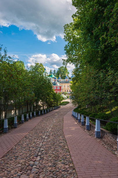 Asphaltierte Straße zum Tempel der Himmelfahrthöhle. Svyato-Uspenskiy Pskovo-Pechersk-Kloster in der Nähe von Pskov, Gotteszdania-Höhle. - Foto, Bild