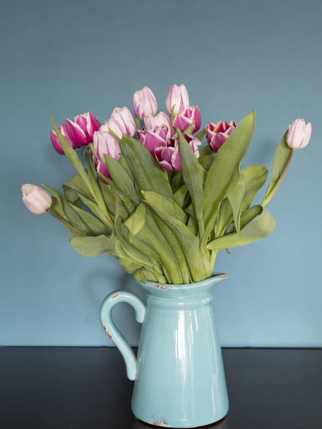 Ramo de flores de tulipán rosa fresco en el estante frente a la pared de piedra. Ver con espacio de copia
 - Foto, Imagen